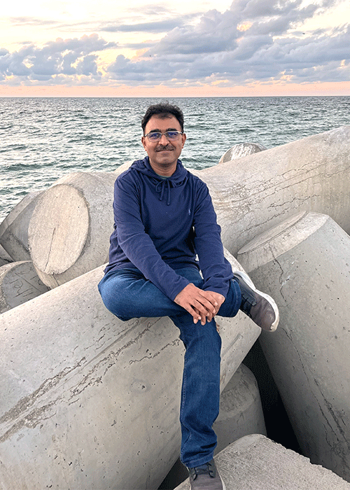 Candid image of Sameer Raniga, MD, FRCR by the sea for RSNA Member Spotlight