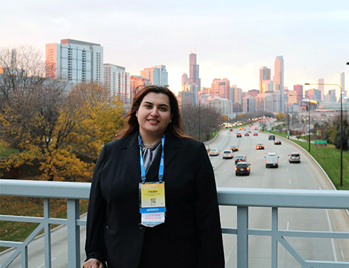 Faezeh Sodagari, MD, radiologist standing on concrete overpass at McCormick Place with the Chicago skyline in the background