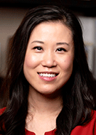 Angela Jia MD PhD smiling woman wearing red dress