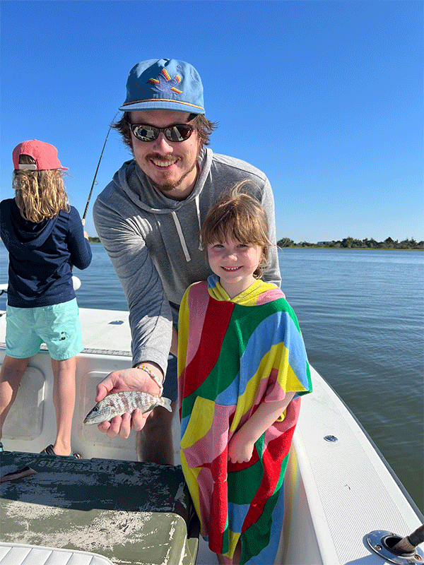 Paul Bunch, MD, on a boat with two children fishing