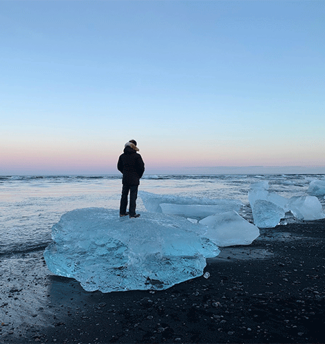 Pedro V. Staziaki, MD, standing at the edge of a body of water on a large ice block