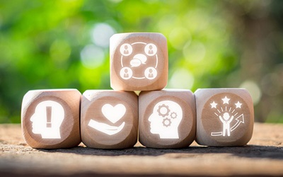 Shutterstock image showing stacked wooden dice with symbols of emotional intelligence