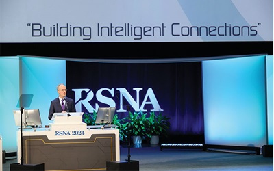 Dr. Curtis P. Langlotz stands at the podium delivering his RSNA 2024 plenary lecture