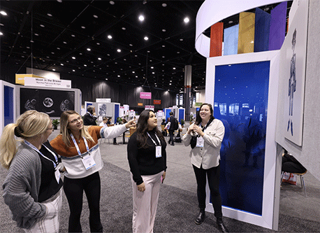 Four people looking at artwork displayed at the RSNA annual meeting