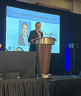 M. Mahesh, PhD, MS at podium receiving a lifetime achievement award