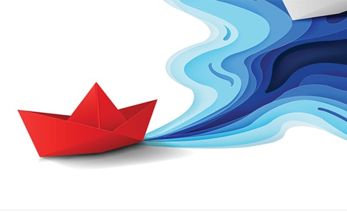 Red paper origami boat appears to float on flat, white water leaving a wake of gradient blue water