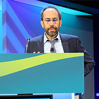 Alexander Drzezga, MD, speaks at a podium at RSNA 2025.