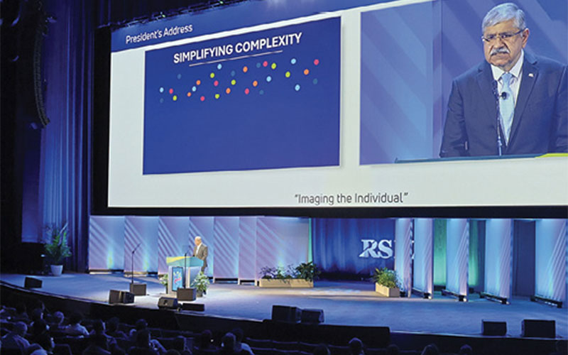 Umar Mahmood, MD, PhD, speaks from the stage of the Arie Crown Theater