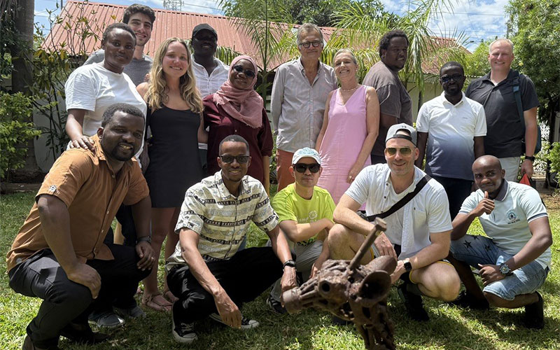 Group of men and women gather outdoors for a photo in Dar es Salaam Tanzania.