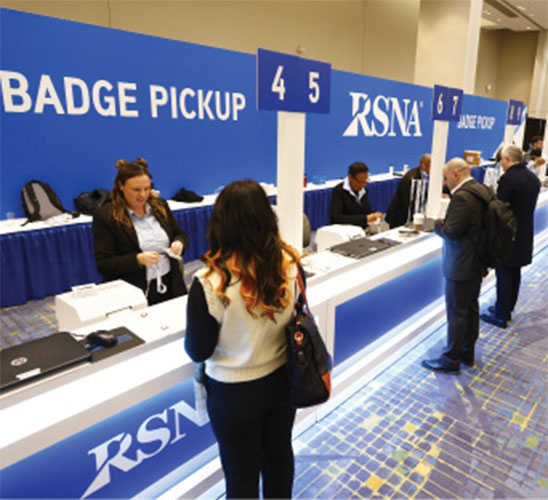 Meeting attendee waits for her badge at the badge pickup counter at the RSNA annual meeting.