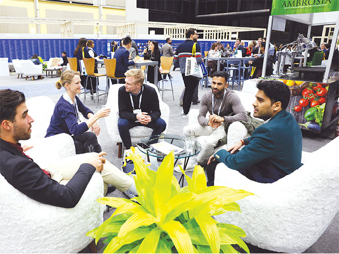 A group of professionals sit around a table in conversation. 