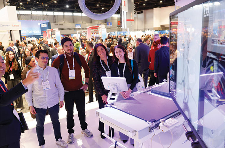 Group of people stand around a technical demonstration at the RSNA annual meeting.