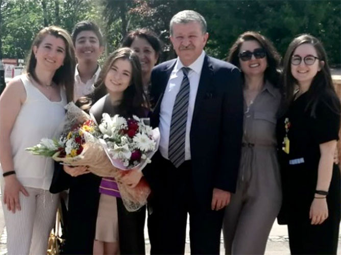 Berat Bersu Ozcan, MD, stands with family members following a graduation ceremony. 
