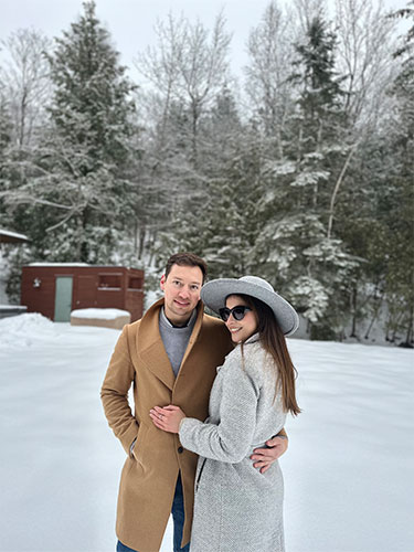 Maria Lucia Brun-Vergara, MD, and partner pose in jackets in front of a snowy landscape. 