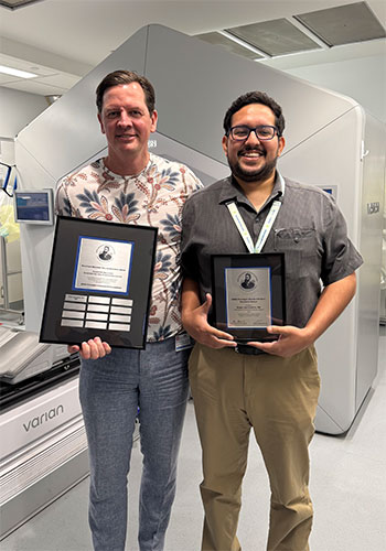 Ruben del Castillo, MD (right), holds his 2025 Roentgen Resident/Fellow Research Award from  Andrew Loblaw, MD (left), professor of Radiation Oncology at Sunnybrook Health Sciences Centre in Toronto, Canada. 