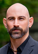 Head shot of Masis Isikbay, MD, wearing a dark suit and dark shirt
